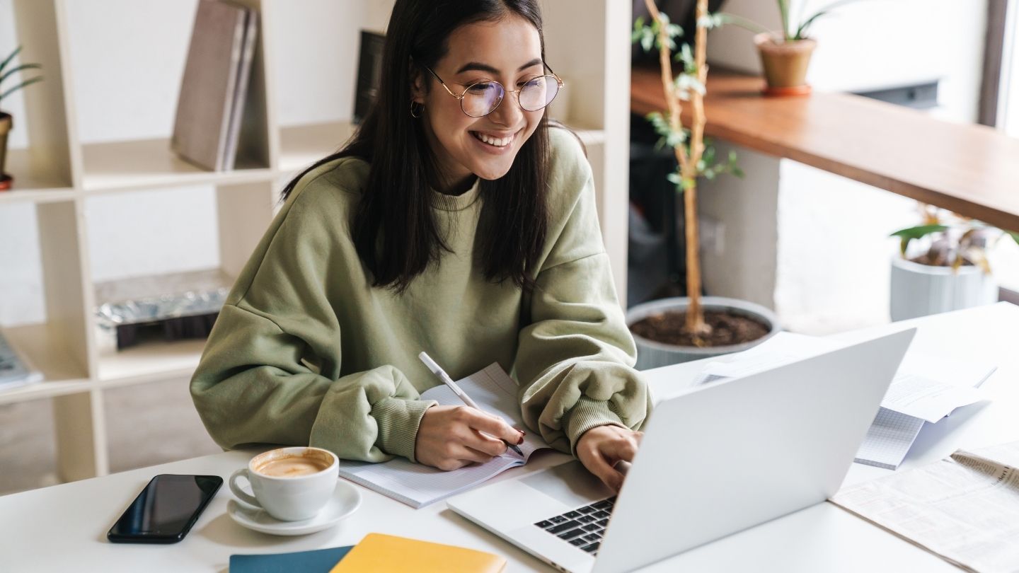 Woman Smiling While Working On A Laptop
